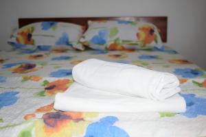 a pile of towels sitting on a bed at Srebrna Nit in Veliko Gradište