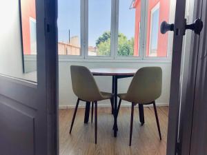 a table and two chairs in a room with a window at Porto Republica Downtown in Porto