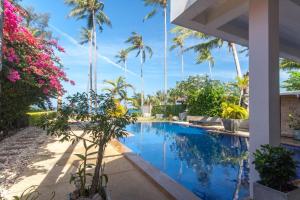 a swimming pool in a villa with palm trees at Malee Beach A1 in Ko Lanta