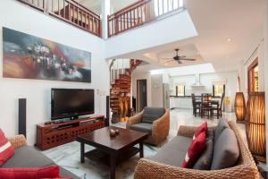 a living room with couches and a flat screen tv at Malee Beach A1 in Ko Lanta
