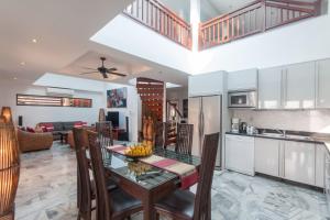 a kitchen and living room with a table and chairs at Malee Beach A1 in Ko Lanta