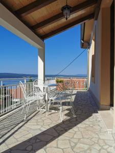 a patio with chairs and tables on a balcony at Apartments Balticadriatic in Dramalj