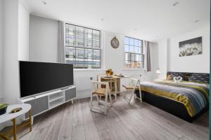 a bedroom with a bed and a flat screen tv at STUDIO IN THE HEART OF THE CITY - ALDGATE ZONE 1 in London
