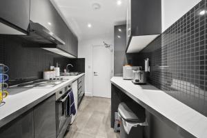 a black and white kitchen with a sink and a stove at STUDIO IN THE HEART OF THE CITY - ALDGATE ZONE 1 in London