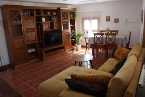 Una sala de estar con un sofá y un comedor. en La Casa Toledana - patio y terraza con vistas, en Toledo