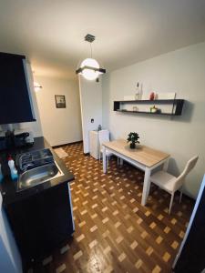een keuken en een woonkamer met een tafel en een wastafel bij City Centre Apartment in Reghin