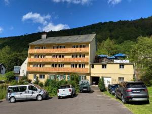 a large building with cars parked in a parking lot at Hôtel Les Mouflons in Le Mont-Dore