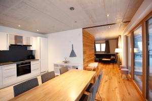 a kitchen and dining room with a wooden table and chairs at Haus Galgenul in Sankt Gallenkirch