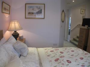 a bedroom with a bed with a lamp and a staircase at The Lantern in Donaghadee