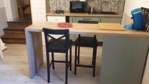 una cocina con una barra con 2 sillas en una mesa en Gîte de village, en La Garde-Adhémar