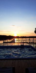 uma piscina com o pôr-do-sol ao fundo em Hotel Tanzanit em Jesionka