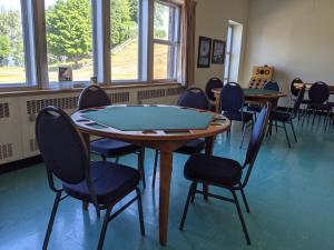 a room with a table and chairs and windows at Manoir d'Youville in Châteauguay Heights