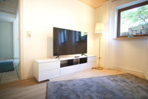 a living room with a flat screen tv on a dresser at Ferienwohnung Am Wingert in Sankt Martin