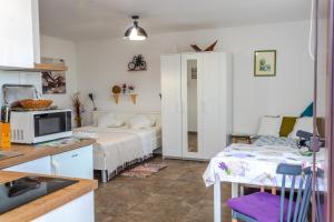 a small room with a bed and a kitchen at Little garden house in Rijeka