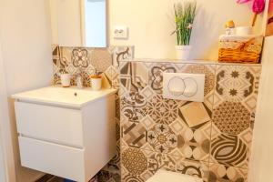 La salle de bains est pourvue d'un lavabo et d'un mur en carrelage. dans l'établissement Little garden house, à Rijeka 26 autres photos