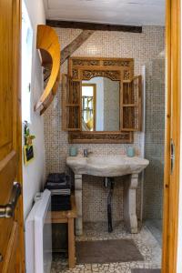 La salle de bains est pourvue d'un lavabo et d'un miroir. dans l'établissement Domaine Les Chillards, à Fauguernon