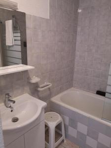 Résidence Perce Neige في لوز سانت سوفير: حمام مع حوض وحوض استحمام ومرحاض