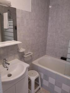 a bathroom with a sink and a tub and a toilet at Résidence Perce Neige in Luz-Saint-Sauveur