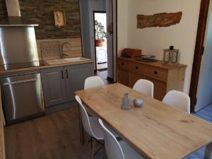 cocina con mesa de madera y sillas blancas en Résidence Perce Neige en Luz-Saint-Sauveur