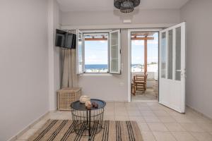 een woonkamer met een tafel en uitzicht op de oceaan bij Porto Vidali in Agios Ioannis