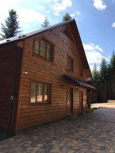 un gran edificio de madera con ventanas laterales. en Ялинка, en Migovo