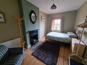 a living room with a bed and a fireplace at Chapel View Cottage in Port Carlisle