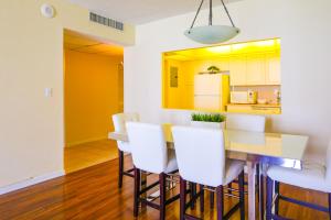 a kitchen and dining room with a table and white chairs at Sunny Isles Ocean Reserve Condo Apartments - 1BR #812 in Miami Beach