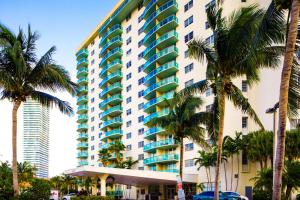 a tall building with palm trees in front of it at Sunny Isles Ocean Reserve Condo Apartments - 1BR #812 in Miami Beach