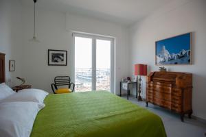 ein Schlafzimmer mit einem großen grünen Bett und einem Fenster in der Unterkunft B&B ICHOME NAPOLI - Maison d'Artiste in Neapel