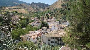 a village in the mountains with houses and trees at Casa Cueva “La Estrella” in Granada