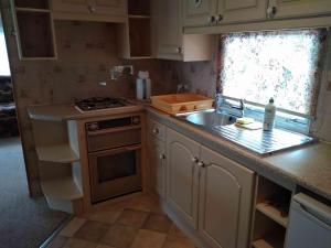 a small kitchen with a sink and a stove at Dar Kalu Małgosia in Kal