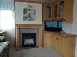 a living room with a fireplace and a tv at Dar Kalu Małgosia in Kal