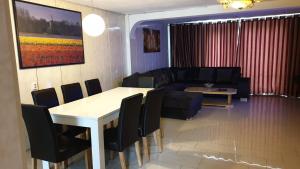 sala de estar con sofá, mesa y sillas en Sewdien's Apartment Beverwaard, en Róterdam