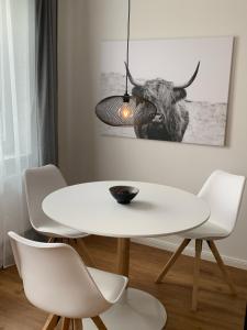 une salle à manger blanche avec une table et des chaises dans l'établissement Ferienwohnung Leonard, à Schleswig