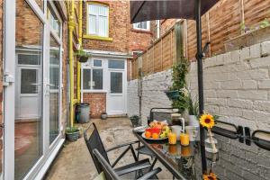 a table with a plate of fruit and an umbrella at Chomley holiday flats in Scarborough