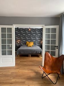 - une chambre avec un lit et une chaise dans l'établissement Ferienwohnung Leonard, à Schleswig