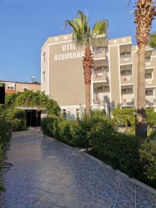 a building with palm trees in front of it at Side Özgürhan Hotel in Side