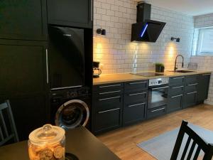 シュレースヴィヒにあるFerienwohnung Leonardのキッチン(黒いキャビネット、シンク、食器洗い機付) +9枚の写真