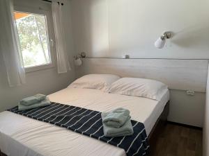 sypialnia z łóżkiem i dwoma ręcznikami na nim w obiekcie Campsite Piccolo w mieście Banjole