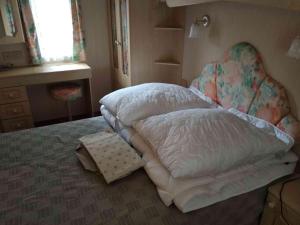 Schlafzimmer mit einem Bett mit einem Kissen und einem Fenster in der Unterkunft Dar Kalu Jas in Kal