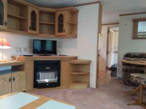 a living room with a television and a fireplace at Dar Kalu Jas in Kal +7 photos