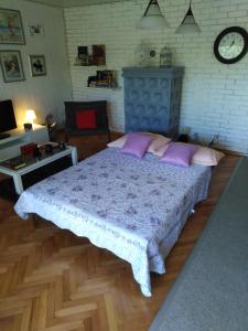 a bedroom with a large bed with purple pillows at Apartman Mimi in Klenovica