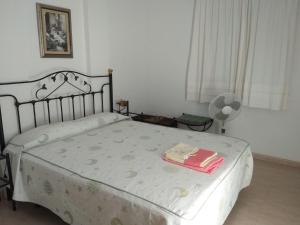 een slaapkamer met een bed met een deken en een ventilator bij Apartamento La Rotonda C-116 in Conil de la Frontera