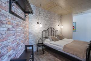 Tamara Luxury Apartments في بليد: غرفة نوم بحائط من الطوب وسرير