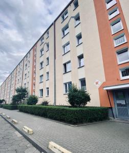 a large apartment building with a sidewalk in front of it at Przytulne mieszkanie na Przymorzu w Gdańsku in Gdańsk