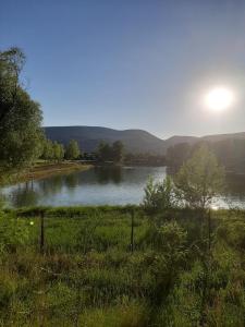 a view of a lake with the sun in the background at Megyeri Apartman in Pócsmegyer