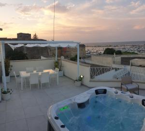 patio con tavolo, sedie e vasca idromassaggio. di Appartamenti porta mare a Otranto