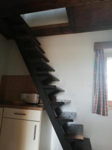 eine Holztreppe in einer Küche mit einem Fenster in der Unterkunft Auerberg Blick in Hainfeld
