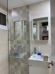 ein Badezimmer mit Dusche, Waschbecken und Spiegel in der Unterkunft Luxury estudio Júpiter minerva in Benalmádena