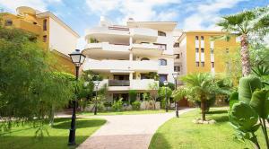 un grande edificio bianco con palme in un parco di Panorama Park a Torrevieja